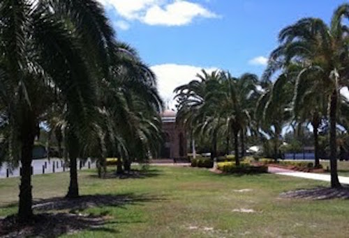 Palm trees line a long-forgotten avenue leading up to a 20th century domed cenotaph.